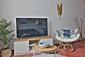 ein Wohnzimmer mit einem großen TV und 2 Stühlen in der Unterkunft Malpica Greek Home in Malpica