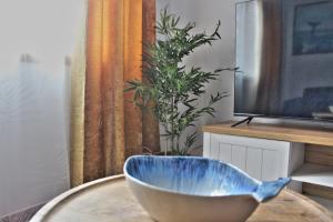 eine blaue Schüssel auf einem Tisch neben einem TV in der Unterkunft Malpica Greek Home in Malpica