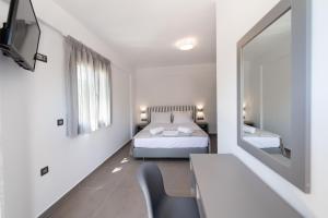 a bedroom with a bed and a desk and a mirror at Aurelia in Nikiana