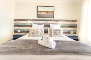 Un dormitorio con una cama con una toalla. en Langebaan Golf Lagoon Haven en Langebaan