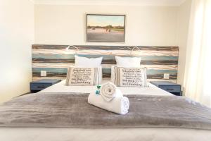 a bedroom with a bed with a towel on it at Langebaan Golf Lagoon Haven in Langebaan