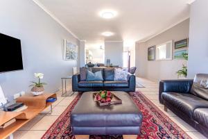 a living room with a couch and a tv at Langebaan Golf Lagoon Haven in Langebaan