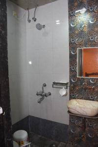 ein Bad mit einer Dusche und einem WC in der Unterkunft amee's retreat in Diveagar
