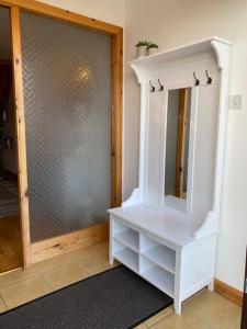 ein Zimmer mit einem weißen Schrank und einem Spiegel in der Unterkunft Enegar Accommodation in Stromness + 14 Fotos