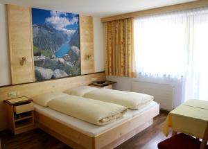 a bedroom with two beds and a painting on the wall at Roasnerhof in Finkenberg +18 photos