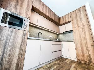 una cucina con armadietti bianchi e forno a microonde di Penthouse apartment Kubínska Hoľa a Dolný Kubín