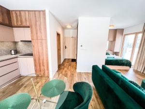 un soggiorno con sedie verdi e una cucina di Penthouse apartment Kubínska Hoľa a Dolný Kubín