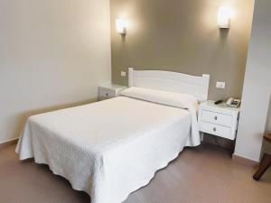 a bedroom with a white bed and a telephone at Hotel O Cruceiro in Caldas de Reis