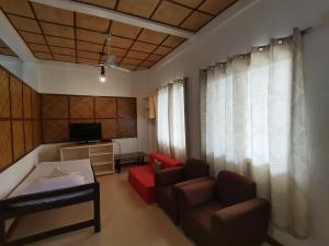 uma sala de estar com um sofá e uma televisão em Nickles Park Resort em Panglao City