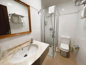 a bathroom with a sink and a shower and a toilet at Hotel O Cruceiro in Caldas de Reis