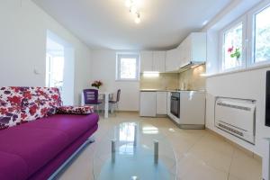 sala de estar con sofá púrpura y mesa de cristal en Apartment Pavlina, en Dubrovnik