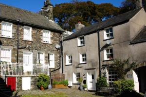 an old stone house with white windows and a red door at Low Nook Cottage - Gorgeous decor in Broughton in Furness