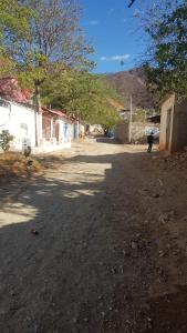 a person walking down a dirt road in a village at Casita mi nuevo amanecer in Santa Marta