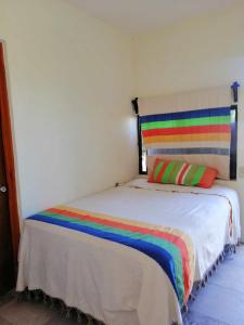 a bedroom with a bed with a rainbow pillow at casa agave in San José del Cabo
