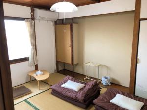 sala de estar con sofá y mesa en ゲストハウスまちかど Guest House MACHIKADO en Ibusuki