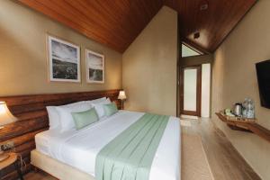 A bed or beds in a room at Log Home Villas at Taman Wisata Bougenville