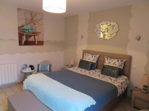 a bedroom with a bed and a chandelier at Chambres d'Hotes La Maison Neuve in Saint-Loup