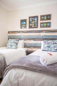 dwa łóżka w pokoju z malowidłem ściennym w obiekcie Langebaan Golf Lagoon Haven w mieście Langebaan