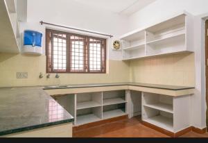 cocina grande con encimera y ventana en Tharayil Apartments, en Kochi