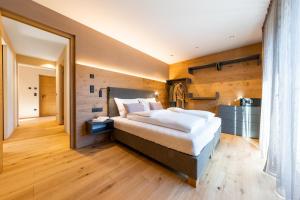 a bedroom with a large bed and a large mirror at Rienz Alpine City Lofts in Brunico