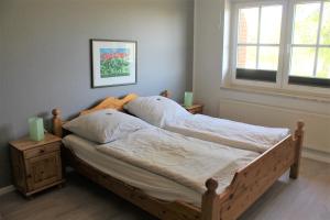 Una cama en un dormitorio con dos velas. en "Pappelhof - Whg 1" en Grömitz