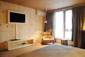 a bedroom with a bed and a tv and a chair at 9Hotel Chelton in Brussels