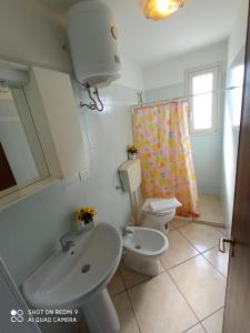 a bathroom with a sink and a toilet and a shower curtain at Residence Poseidon in Lido Marini +27 photos