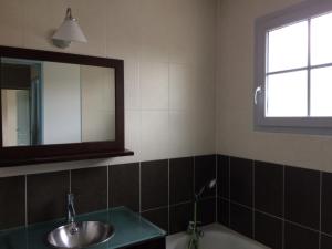 a bathroom with a sink and a mirror and a tub at appartement T3 in Aureilhan