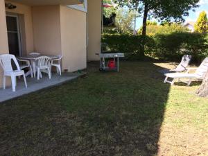 a yard with chairs and a table and a table and chairs at appartement T3 in Aureilhan