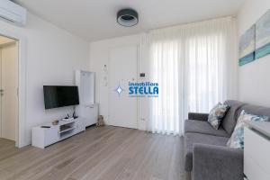 a living room with a couch and a flat screen tv at Villaggio Le Tropezien in Lido di Jesolo