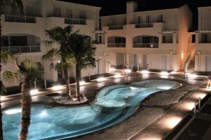 - une piscine en face d'un bâtiment la nuit dans l'établissement Villaggio Le Tropezien, à Lido di Jesolo