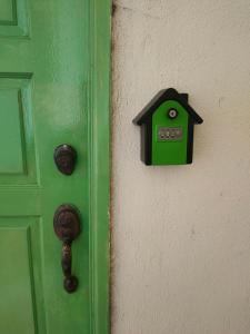 a green door with a bird house on it at Jeram Staycation in Jeram +3 photos