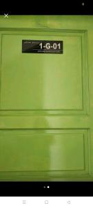 a green garage door with a sign on it at Jeram Staycation in Jeram