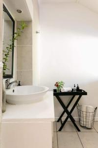 a white bathroom with a tub and a table at Boutique Guesthouse Hanover in Hanover