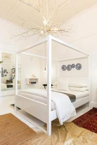 a white bedroom with a white canopy bed at Boutique Guesthouse Hanover in Hanover