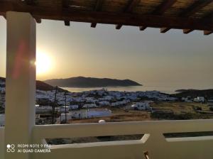 a view of a city from a window with the sunset at Villa Argentosa in Kimolos