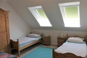 a attic room with two beds and two skylights at "Pappelhof - Whg 7" in Grömitz