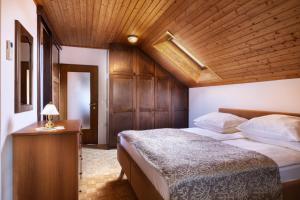 a bedroom with a large bed and a wooden ceiling at Lake Bled Apartment Zerovec in Bled