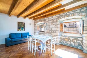 a dining room with a table and a blue couch at Apartments Martecchini in Dubrovnik