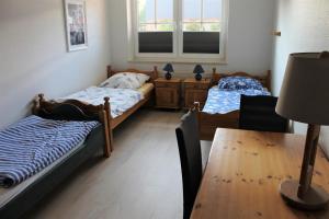 duas camas num quarto com uma mesa e uma mesa sidx sidx em "Pappelhof - Whg 3" em Grömitz