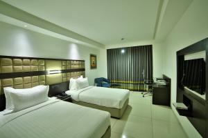 Habitación de hotel con 2 camas y TV de pantalla plana. en HOTEL G EXPRESS Formerly Known as TGB Express en Ahmedabad