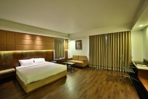 um quarto de hotel com uma cama e uma secretária em HOTEL G EXPRESS Formerly Known as TGB Express em Ahmedabad