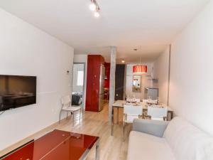 sala de estar con sofá blanco y comedor en Precioso apartamento reformado en el sardinero, en Santander