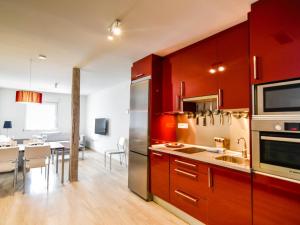 kuchnia z czerwonymi szafkami i jadalnią w obiekcie Precioso apartamento reformado en el sardinero w mieście Santander +7 zdjęć