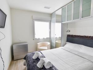 sypialnia z łóżkiem i ręcznikami w obiekcie Precioso apartamento reformado en el sardinero w mieście Santander