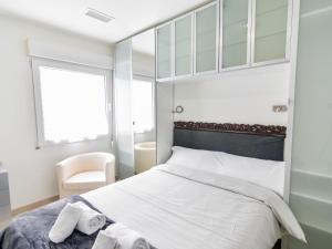 sypialnia z łóżkiem, krzesłem i oknem w obiekcie Precioso apartamento reformado en el sardinero w mieście Santander