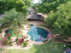an aerial view of a swimming pool with a thatch roof at Hornbill Private Lodge Mabalingwe in Mabula