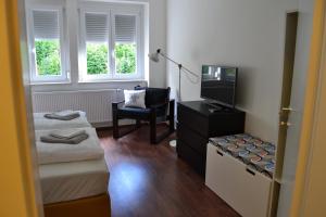 a room with two beds and a tv and a chair at Ferienwohnung Rockside in Arnoldstein