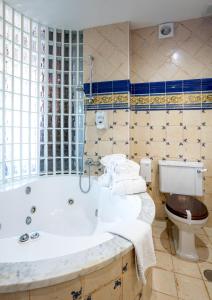 a bathroom with a tub and a toilet at Posada la Leyenda in Santillana del Mar