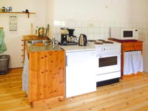 uma cozinha com um fogão branco e um lavatório em Apartment STRYN II em Stryn
